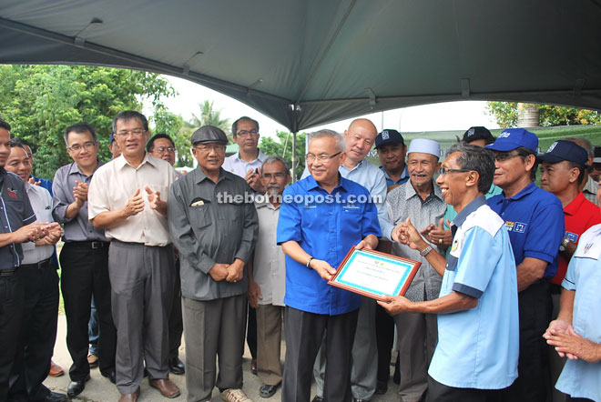 Talib presents a ‘handing over’ document of the jetty to Rahim Wahab who is the chairman of Persatuan Penambang Bumiputera Bintulu.